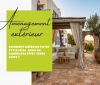 Vue d'ensemble aspirationnelle d'un patio style Ibiza baigné de soleil, combinant murs blancs, pergola en bois et un sol authentique en carrelage terre cuite vieillie.