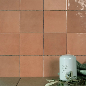 Faïence murale carrée effet zellige tons terracotta et abricot brillant, modèle Zellij Apricot d'Estudio Ceramico, format 12,5x12,5 cm.
